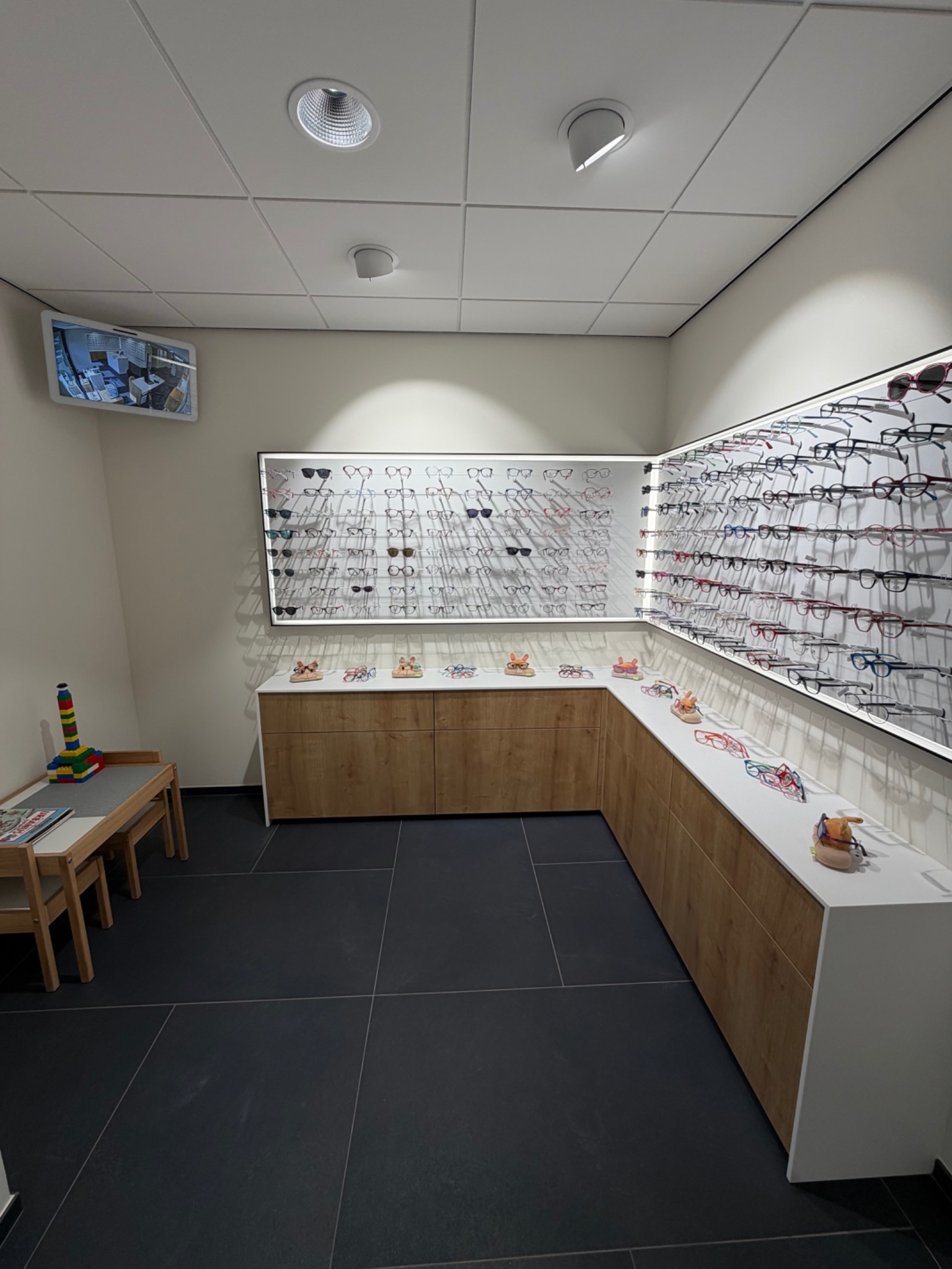 Overzicht van de kinderhoek met kinderbrillen en speeltafel bij Petillion Optiek